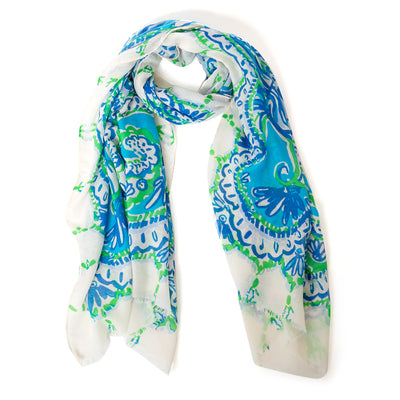 The Blue Bali Scarf with a white background and hints of green