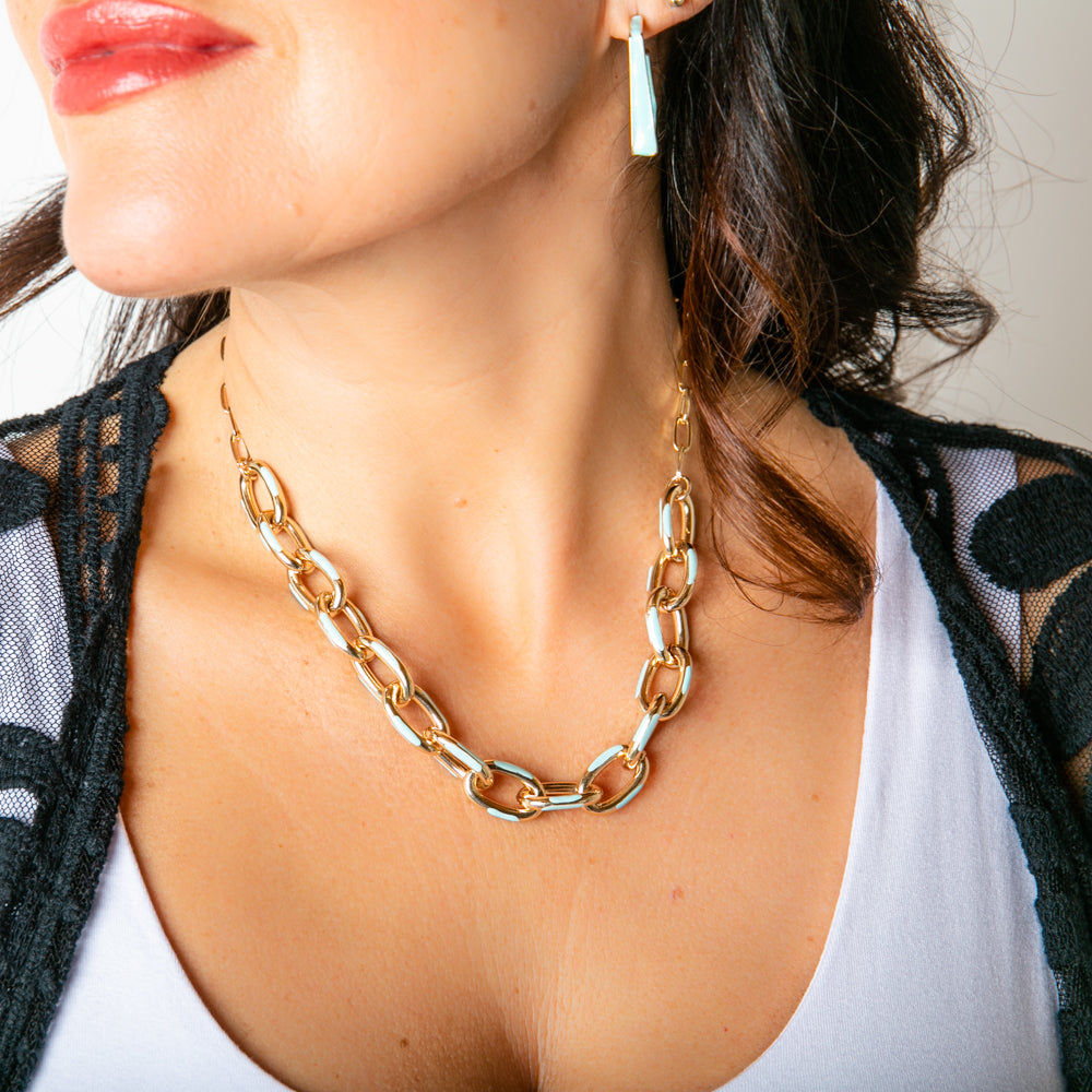 The Enya Necklace in gold with hints of turquoise blue. Statement women's jewellery