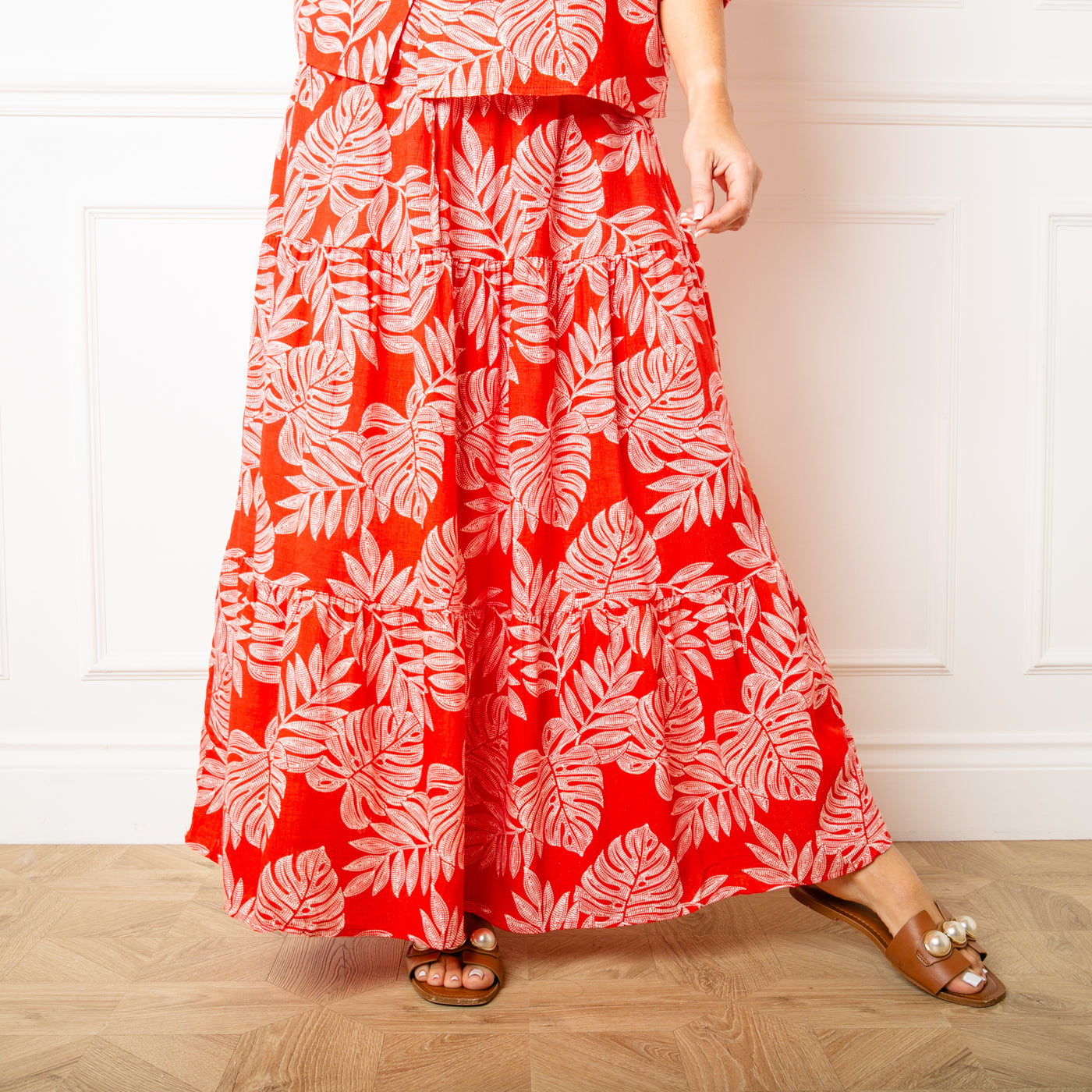 The red Linen Leaf Tiered Skirt in a maxi skirt length with a tiered silhouette