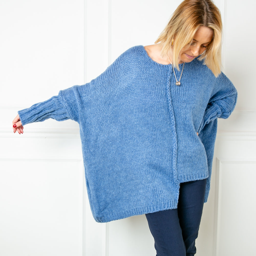 Model showcases the denim oversized jumper from Tilley and Grace. It has a high cuff with a cable stich down the front of the jumper to a wonky hem line. 
