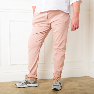 Plus size stretch trousers in blush pink with pockets on either side. The bottom hem can be rolled up to any length 