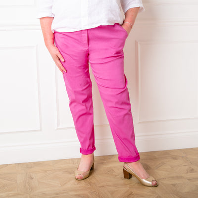 Plus size stretch trousers in fuchsia pink with pockets on either side. The bottom hem can be rolled up to any length 