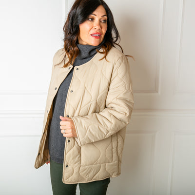 The Quilted Jacket in beige cream, collarless with a round neckline and long sleeves 