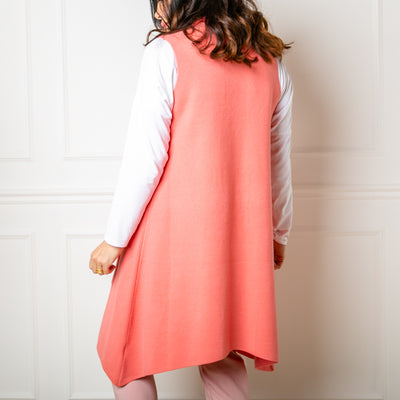 The Sleeveless Cardigan in coral pink orange which is great for adding a pop of colour to any outfit