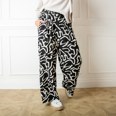 The Twist Trousers in black featuring a fun white abstract squiggle pattern 