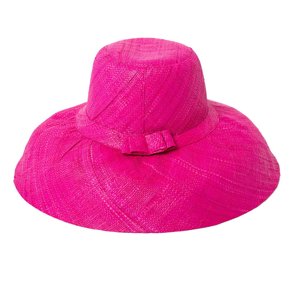 The bright pink Versailles Sun Hat with a wide brim and a bow detail around the circumference 