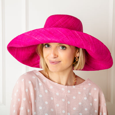 The Versailles Sun Hat in bright pink handmade in Madagascar from sustainable raffia