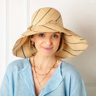 The pinstripe natural brown Versailles Sun Hat Which can be styled in lots of different ways with the brim folded up or down