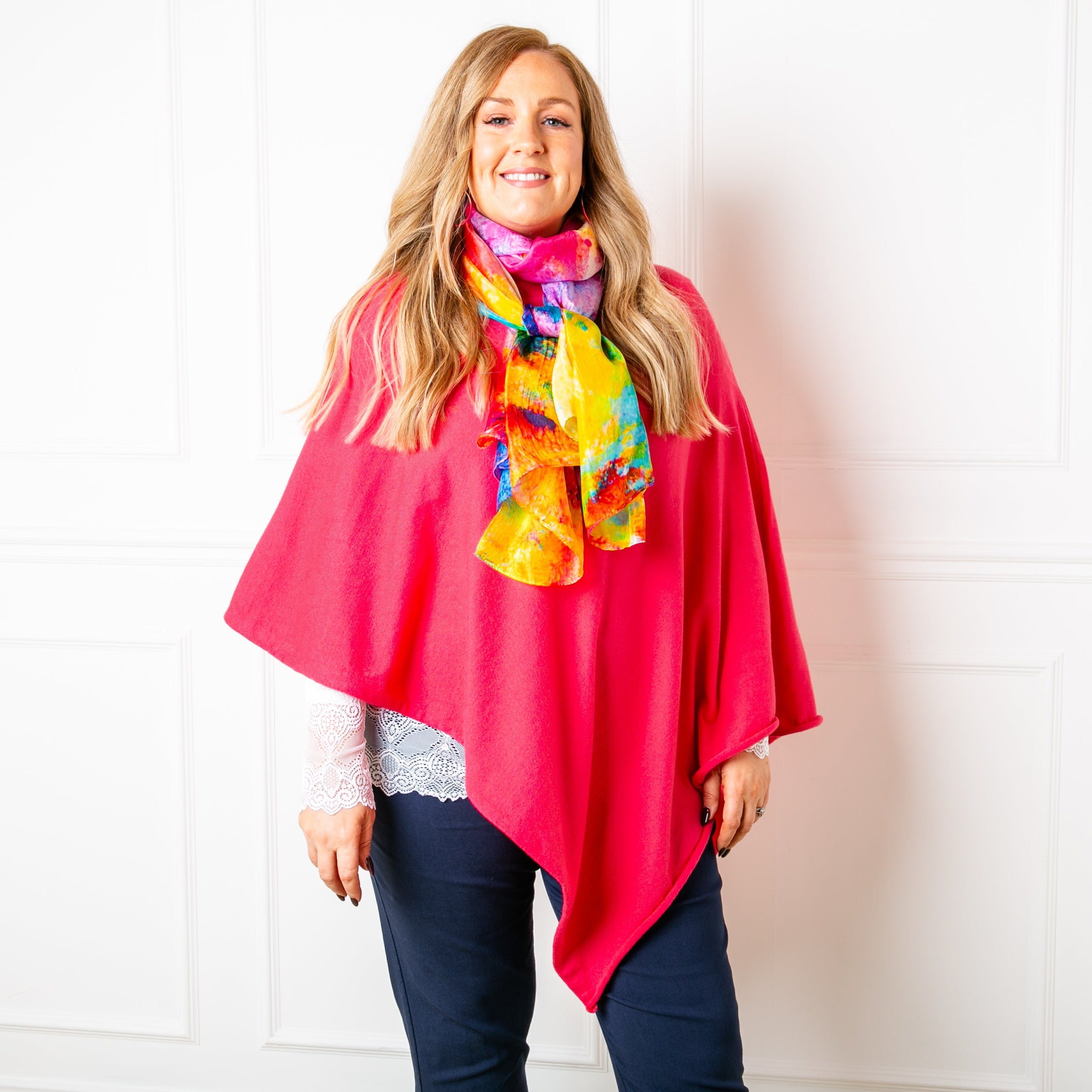 Coral poncho for women pictured styled with a colourful silk scarf