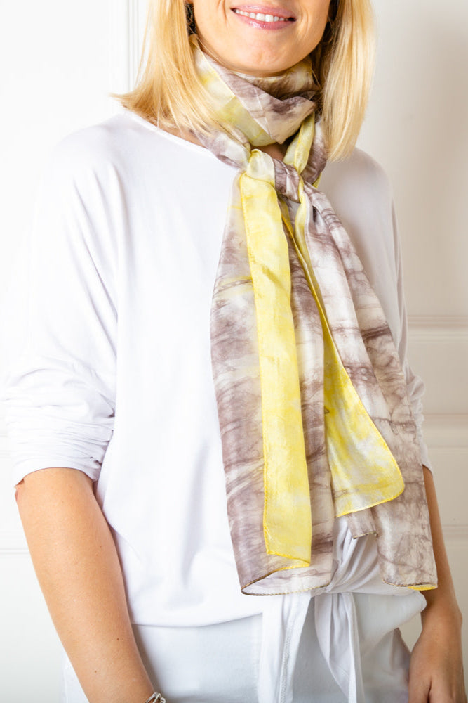 The grey and yellow tie dye print 100% silk demi scarf in a slimmer width to our regular silk scarf collection 