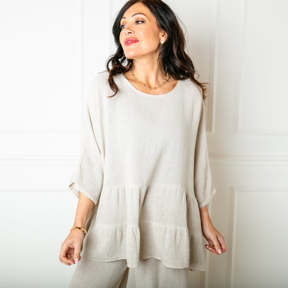 The Linen Blend Tiered Top in stone cream with a loose tiered peplum silhouette