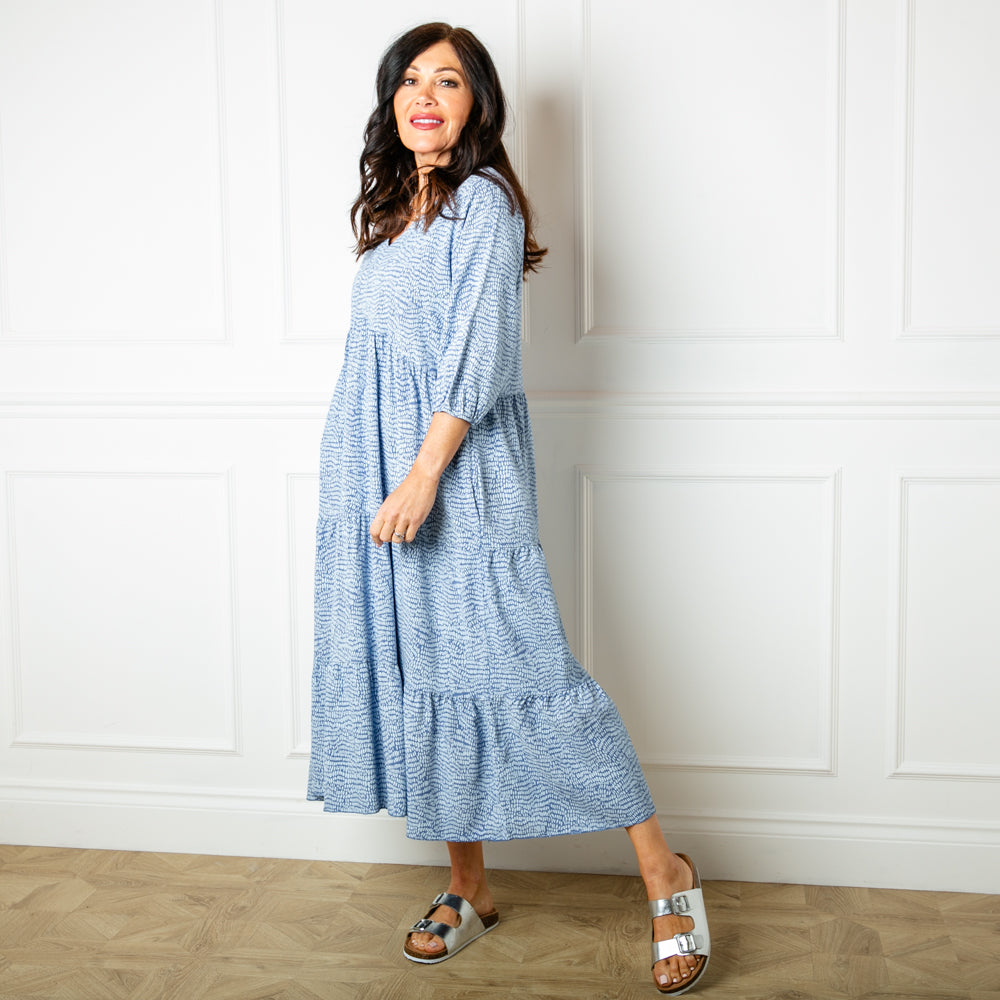 The dusky blue Pebble Print Tiered Dress featuring a detailed spotty pattern with accents of white