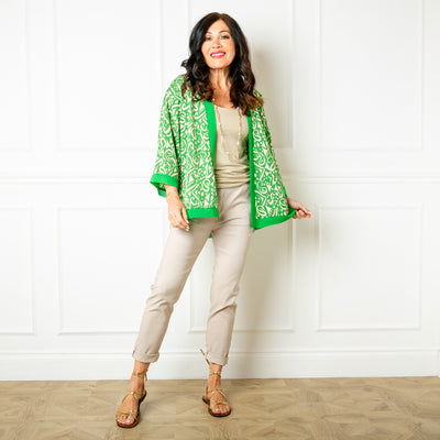 The Lightweight Graphic Kimono in green with 3/4 length flared sleeves in a thin, light fabric.