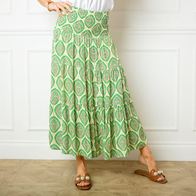 The Flora Stamp Tiered Skirt in green with a tiered silhouette in a midi length