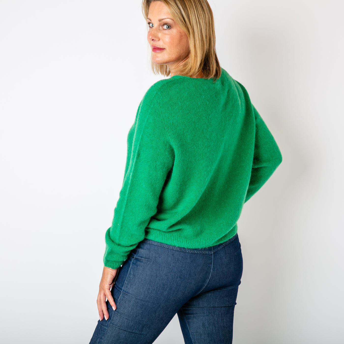 The emerald green Alpaca Blend V Jumper in a cropped length with a seam detail on either arm