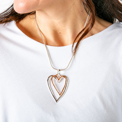 The rose gold and silver Amara Necklace with layered heart pendants 