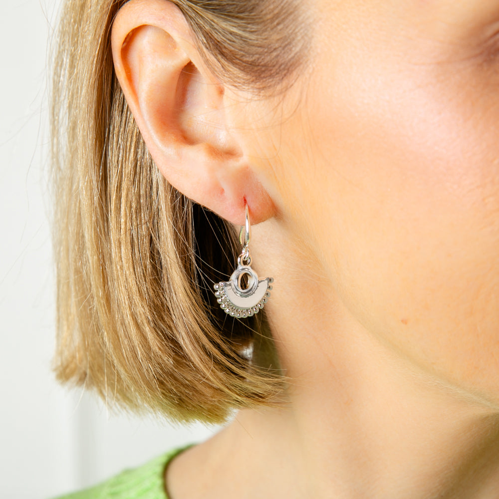 The Bay Earrings in silver with a fun fan shaped pendant, perfect for adding a bit of character to an outfit
