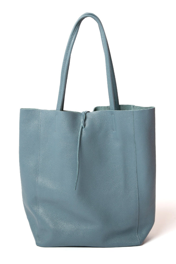 The denim blue Berlin Leather Tote Bag with a tie detail at the opening for fastening