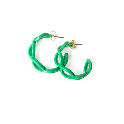 The Billie Earrings in emerald green with a twisted intertwined hoop design 