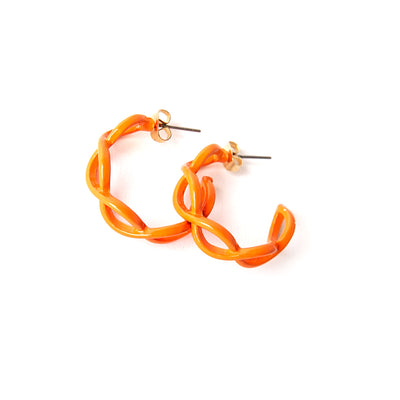 The Billie Earrings in orange with a twisted intertwined hoop design 