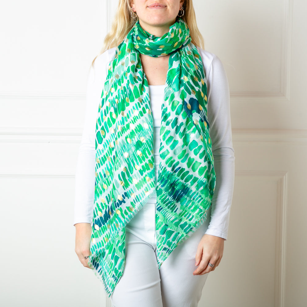 The green Bora Bora Scarf featuring a beautiful spotty block print pattern with hints of gold foil dotted throughout