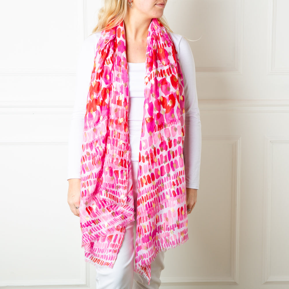 The pink Bora Bora Scarf featuring a beautiful spotty block print pattern with hints of gold foil dotted throughout