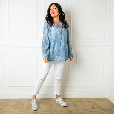 The dusky blue Botanical Cotton Blouse with a collarless v neckline and buttons down to the bust