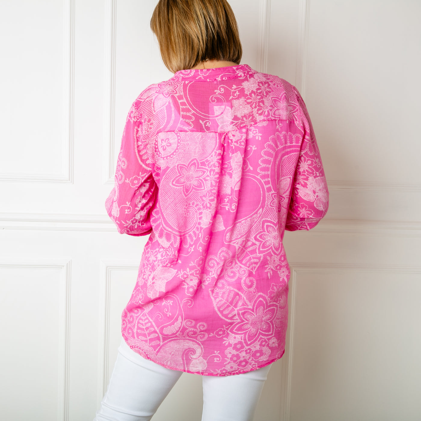 The pink Botanical Cotton Blouse with a collarless v neckline and buttons down to the bust