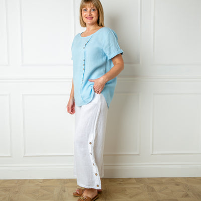The blue Button Down Linen Top with small wooden button detailing down the front of the top 