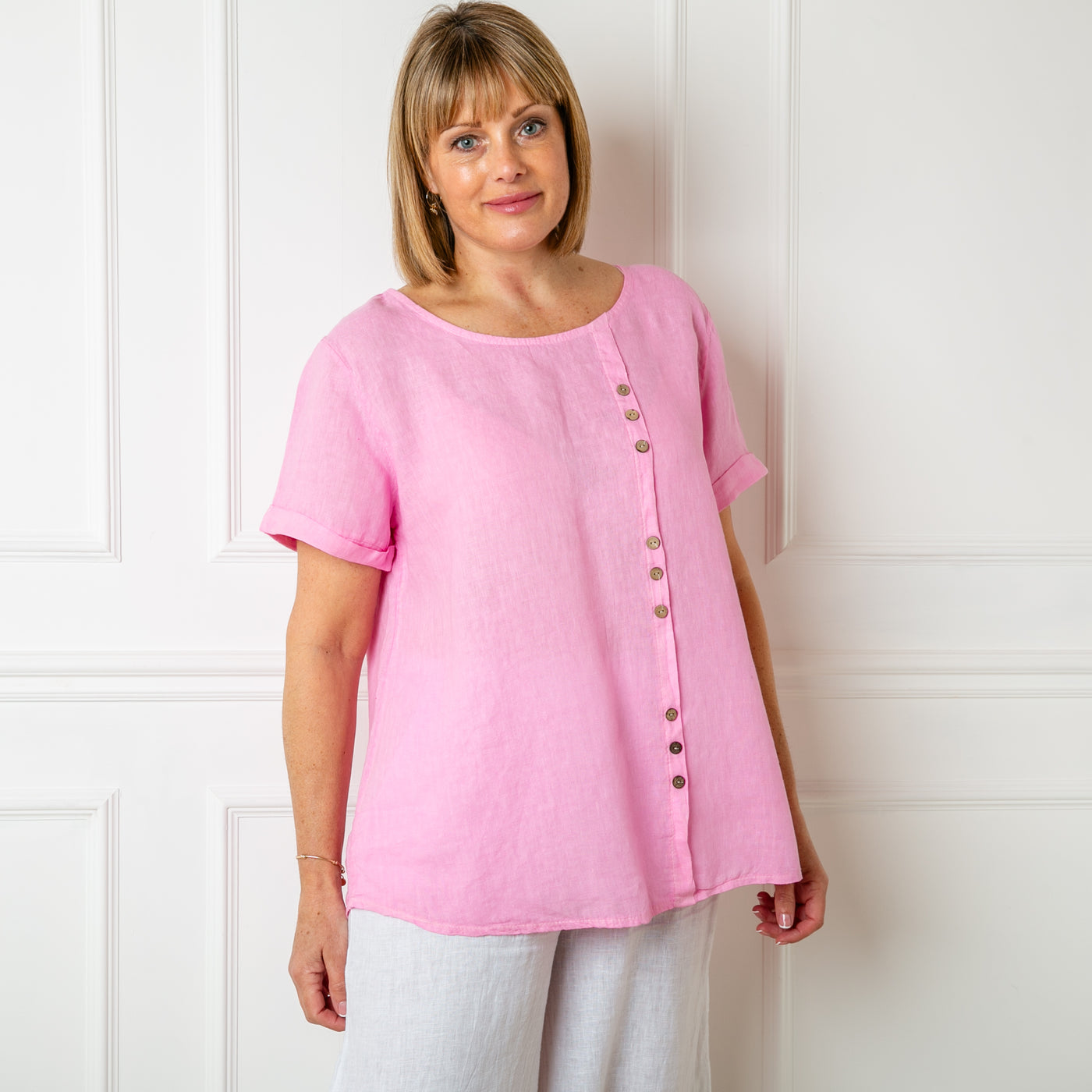 The pink Button Down Linen Top with short sleeves and a round neckline