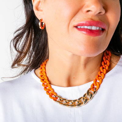 The orange Camilo Necklace with a chunky chain, perfect for adding a pop of colour to any outfit. Statement jewellery.