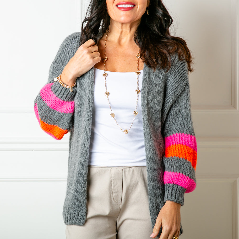 The Contrast Stripe Cardigan in charcoal grey with orange and pink stripes along the sleeves