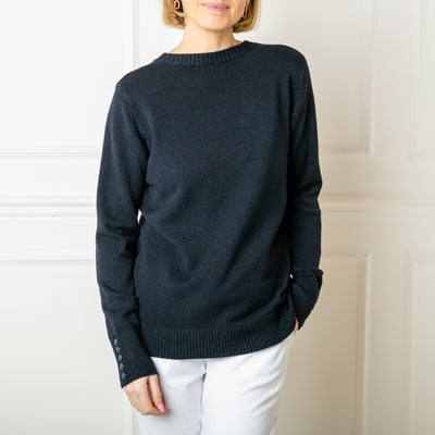 The Crew Neck Button Jumper in navy blue with long sleeves with button detailing along the cuffs