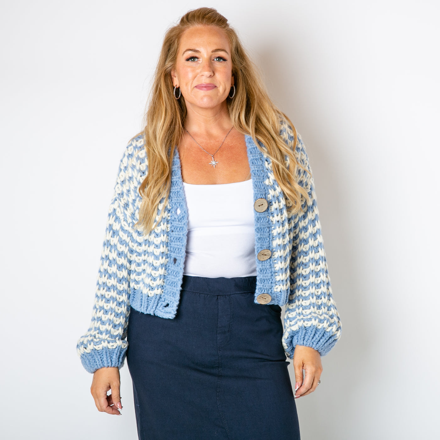 The blue Cropped Chunky Knit Cardigan with ribbed detailing around the cuffs opening and bottom hemline