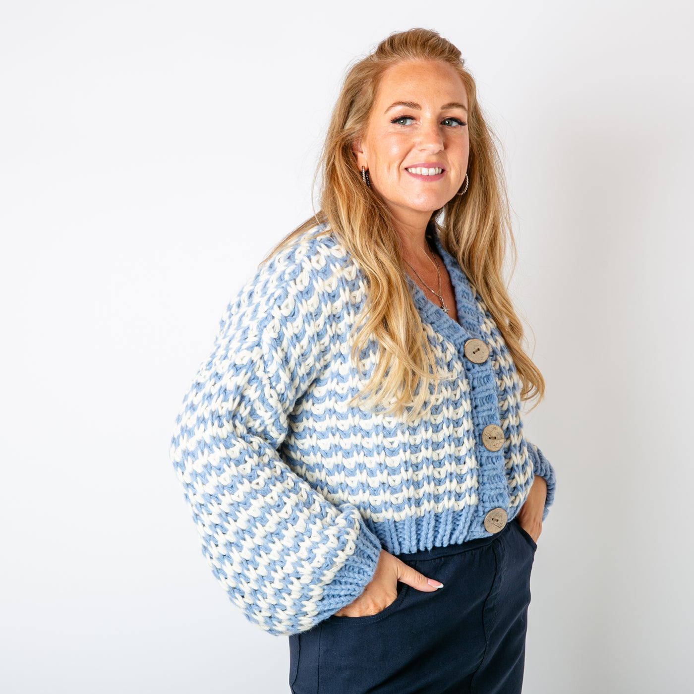 The blue Cropped Chunky Knit Cardigan with large wooden buttons down the front for fastening