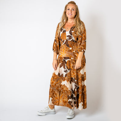 The tan brown Dahlia Print Tiered Dress featuring a bold and vibrant floral pattern