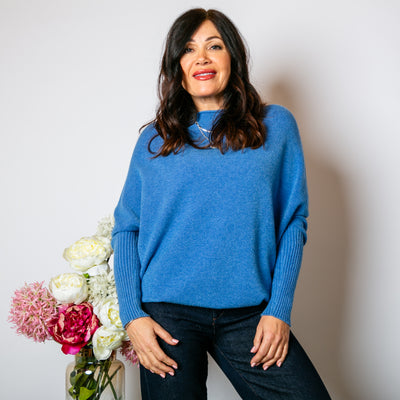 The Drop Sleeve Jumper in denim blue with long sleeves that have a ribbed detailing to the elbow