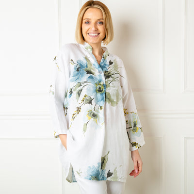 The white floral Linen Top featuring a beautiful flower design across one side of the bodice and the sleeves