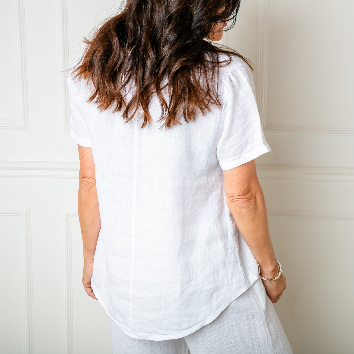 The white Frill Neck Linen Top featuring a fun spotty pattern, embroidered onto the front of the top