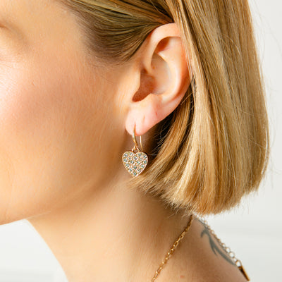 The Gigi Earrings in gold with a heart shape and sparkly gem diamanté's in the middle