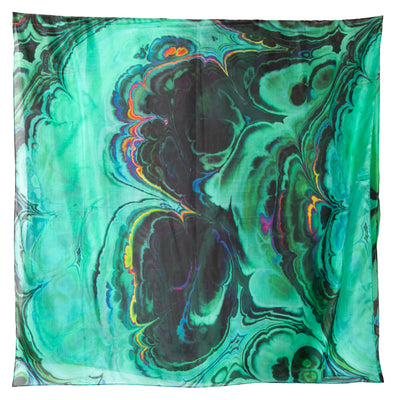A flat lay of the green oil spill scarf, showing burst of green, black, blue and various colours.
