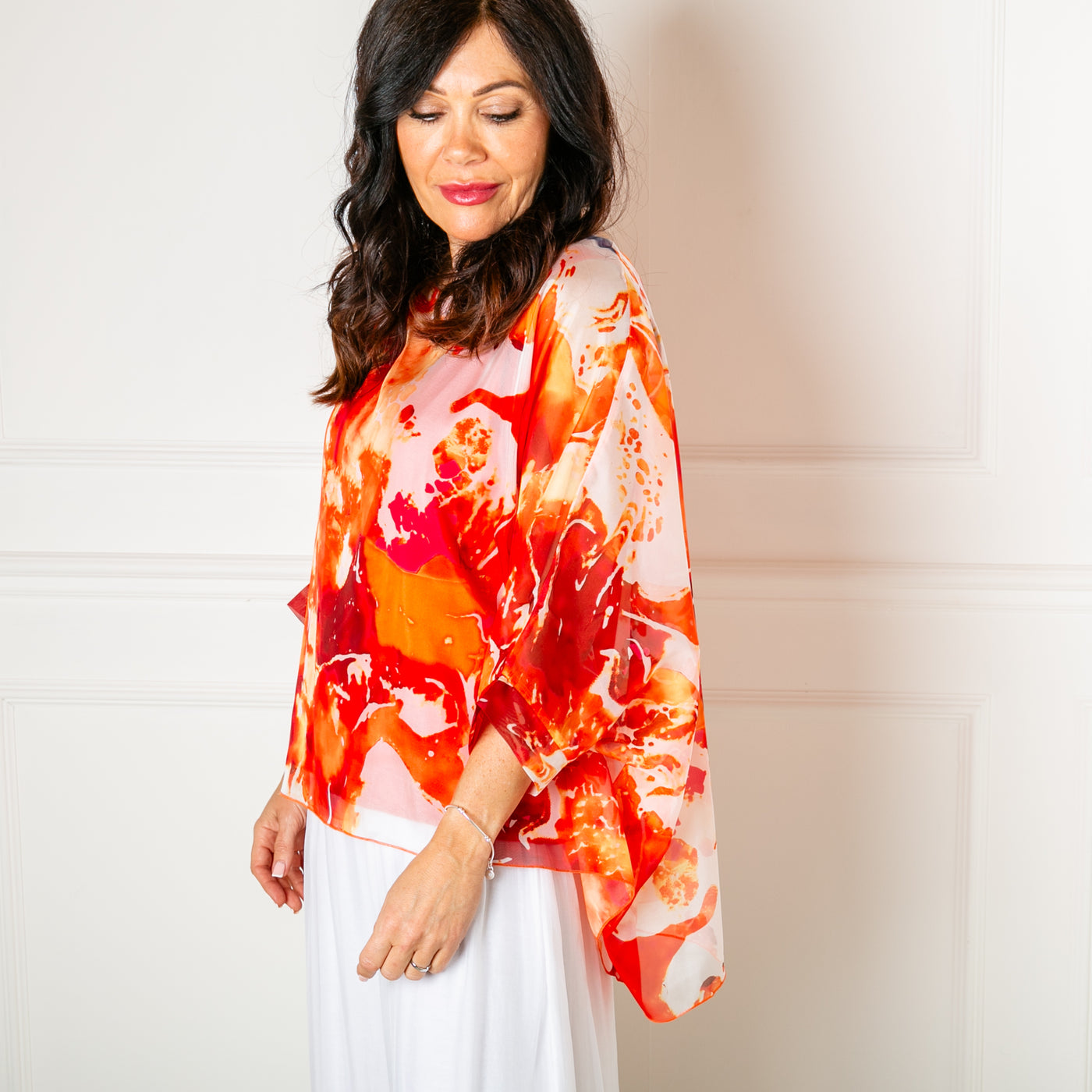 The orange Ink Blot Blouse made up of a lightweight silky material and a stretchy lining underneath