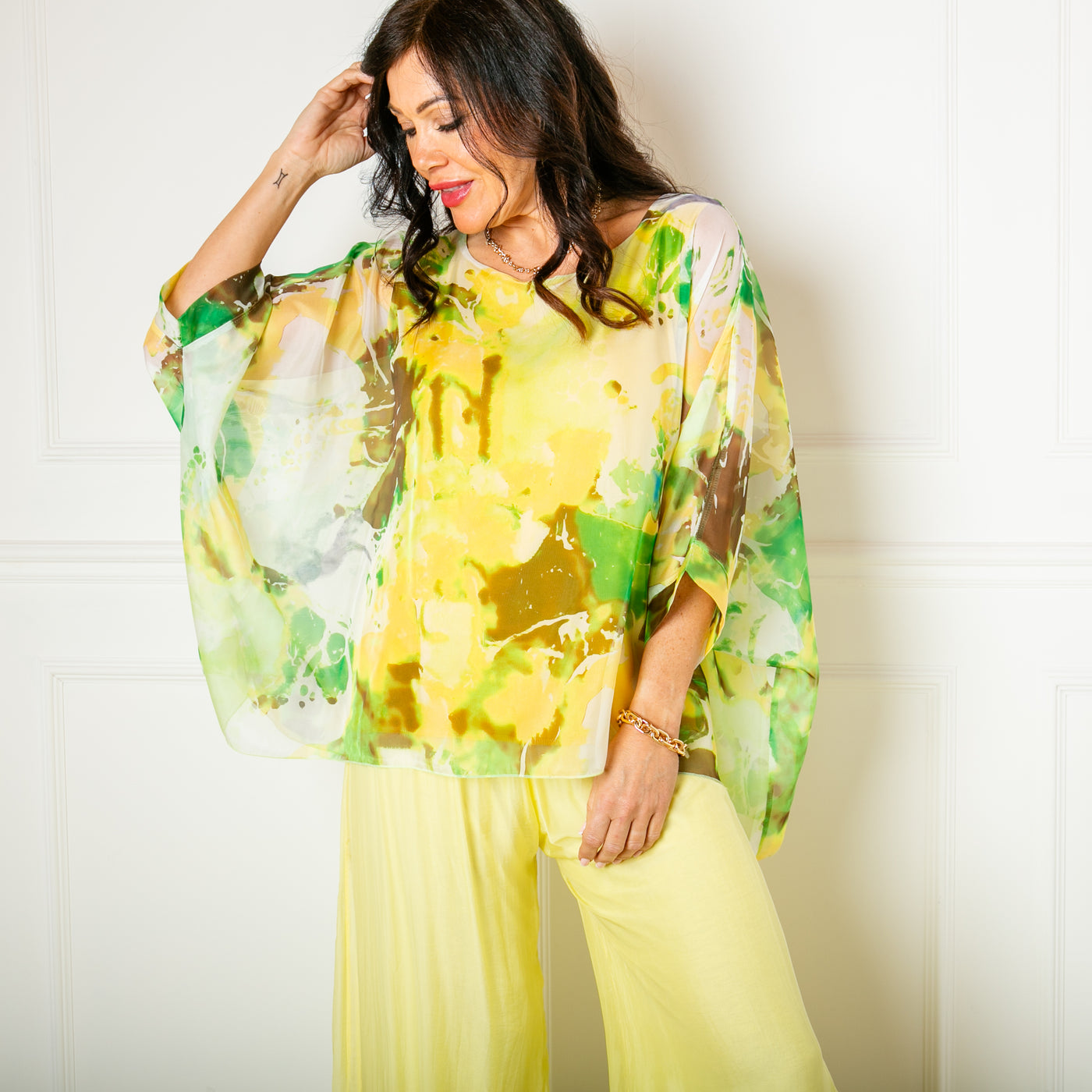 The yellow Ink Blot Blouse made up of a lightweight silky material and a stretchy lining underneath