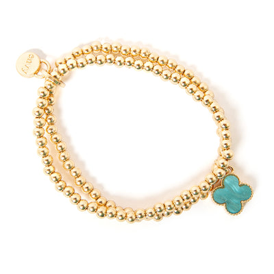 The blue Ivy Charm Bracelet made up of two gold beaded elasticated bands joined together with a charm