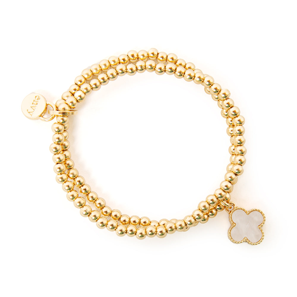 The white Ivy Charm Bracelet made up of two gold beaded elasticated bands joined together with a charm