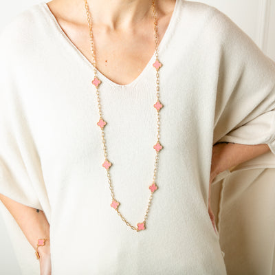 The Ivy Necklace in gold with pink sparkly clover pendants spread along the chain