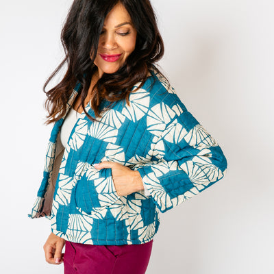 The teal blue Kimono Pattern Quilted Jacket with pockets on either side of the hips