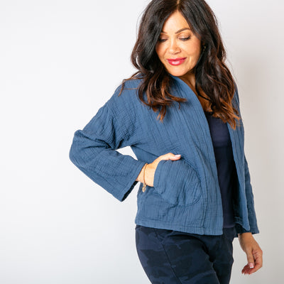 The denim blue Kimono Quilted Jacket with pockets on either side of the waist