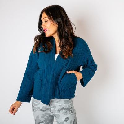 The teal blue Kimono Quilted Jacket with pockets on either side on either side of the waist