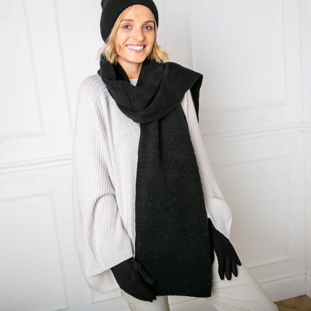 The Layla Scarf in black made from a ribbed knitted blend of wool and viscose